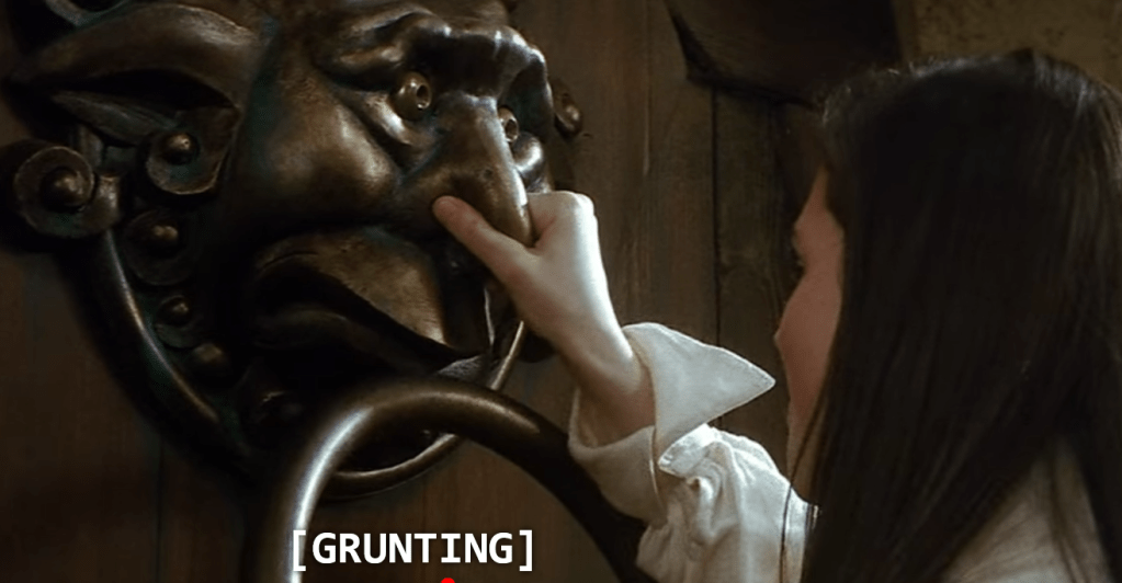 Screen capture from the movie "Labrynth" depicting Sarah holding the nose of a living brass doorknocker, with the sound capture [Grunting} showing.